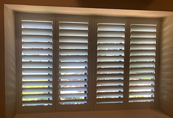 Plantation shutters adding ambiance to a living room window in Arcadia